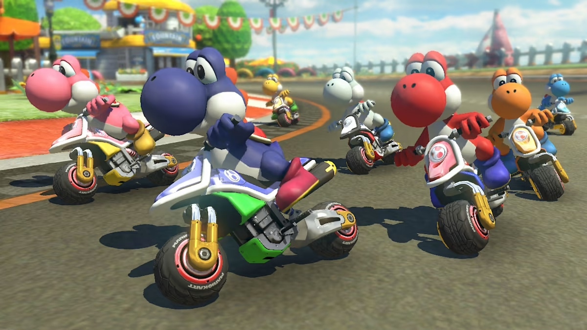 Colorful Yoshis race in Mario Kart 8 Deluxe / Seven differently-colored Yoshis race on motorcycles around a bend in a Mario Kart 8 Deluxe track. / Image credit: Nintendo