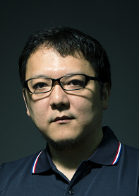 Hidetaka Miyazaki color portrait / Close-up colour portrait photo of Hidetaka Miyazaki, a Japanese man wearing glasses and a polo shirt. / Image credit: FromSoftware, Inc.